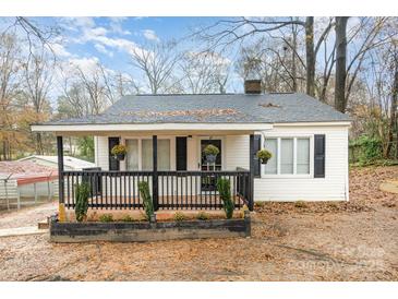 White house with black accents, covered porch, and landscaping at 412 N Vance St, Gastonia, NC 28052