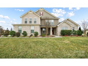 Beautiful two-story home with brick and siding, a well-manicured lawn, and lovely landscaping at 501 Alucio Ct, Matthews, NC 28104