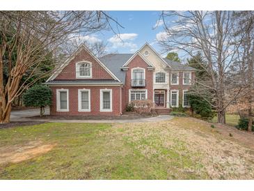 Brick two-story house with a manicured lawn and mature trees at 11805 Prestmoor Ct, Charlotte, NC 28262