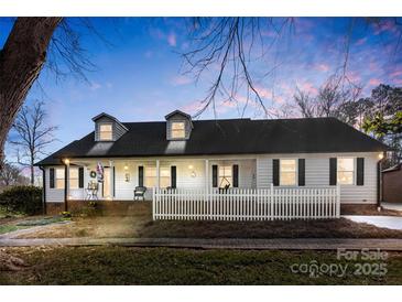 Charming ranch home with white exterior, front porch, and picket fence at 320 Belwood Dr, Belmont, NC 28012