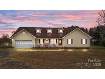 Ranch-style home with attached garage, front porch, and landscaped yard at 36190 Millingport Rd, New London, NC 28127