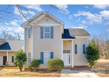 Tan two-story house with blue shutters and a paved driveway at 3821 Bullard St, Charlotte, NC 28208