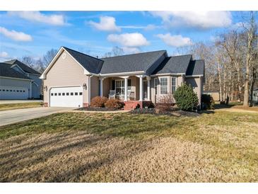 Tan house with gray roof, attached garage, and a front porch at 489 Maple Ridge Cir, Salisbury, NC 28147