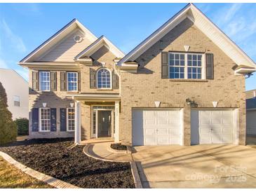 Two-story brick home with a two-car garage and landscaped yard at 8835 Merrie Rose Ave, Charlotte, NC 28213