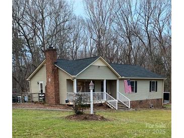 Tan ranch house with a porch and American flag, nestled on a spacious lawn at 1025 Twin Lakes Rd, Rock Hill, SC 29732