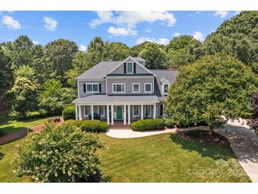 Stunning two-story home with a large covered front porch, green front door, and well-manicured lawn at 110 Lynbrook Dr, Davidson, NC 28036