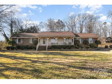 Brick ranch house with covered porch and spacious lawn at 1318 Gum Branch Rd, Charlotte, NC 28214