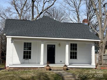 Charming white home features a covered front porch, black front door, and well-maintained landscaping at 506 S Church St, Salisbury, NC 28144