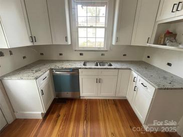 Updated kitchen with stainless steel appliances, granite countertops, and white cabinetry at 506 S Church St, Salisbury, NC 28144