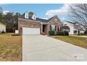 Charming brick home featuring a two-car garage, dormer windows, and manicured landscaping at 529 Veloce Trl, Fort Mill, SC 29715