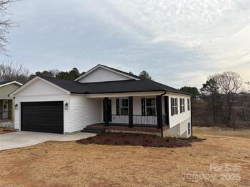 Newly constructed home with white siding, black shutters, and a black garage door at 106 Gilliatt St, Shelby, NC 28150