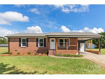 Brick ranch home with a covered porch, new landscaping, and a carport at 2525 Oxford Cir, Lancaster, SC 29720