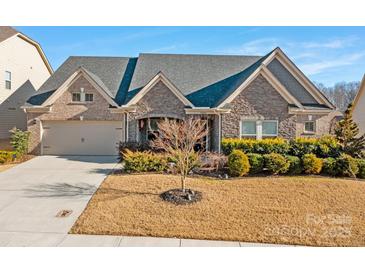 Brick front house with 2-car garage, landscaping, and a large front yard at 12904 Vermillion Xing, Huntersville, NC 28078