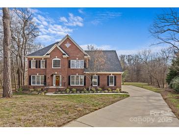 Brick two-story house with a paved driveway and landscaping at 2050 Stoney Creek Nw Dr, Concord, NC 28027