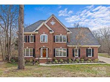 Stunning two-story brick home with a well-manicured lawn and mature trees at 2050 Stoney Creek Nw Dr, Concord, NC 28027