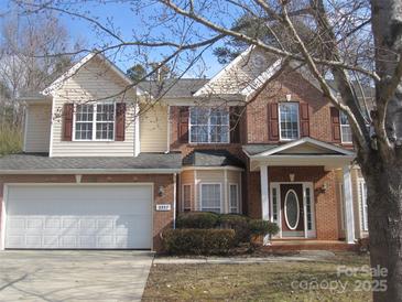 Charming two-story home with brick and siding exterior and attached two-car garage at 2327 Axford Ln, Matthews, NC 28105