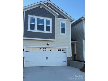 Two-story house with gray and beige siding, white garage door, and landscaping at 260 Laura Elizabeth Ln, Clover, SC 29710