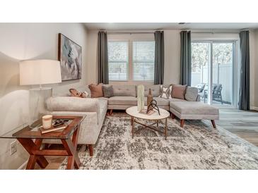 Bright living room showcasing a gray couch, decorative rug, and a patio view at 280 Laura Elizabeth Ln, Clover, SC 29710