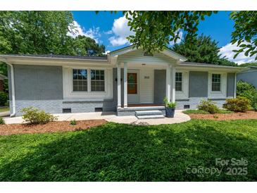 Charming single-story home featuring a well-manicured lawn, painted brick, and a welcoming front porch at 3531 Enfield Rd, Charlotte, NC 28205
