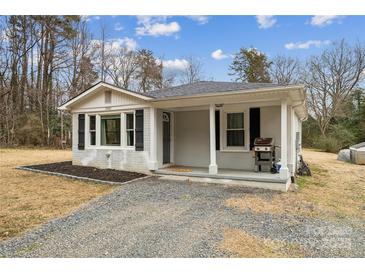 Charming single-story home featuring a cozy front porch, updated exterior paint, and a well-maintained gravel driveway at 5483 Paulmo Dr, Charlotte, NC 28216