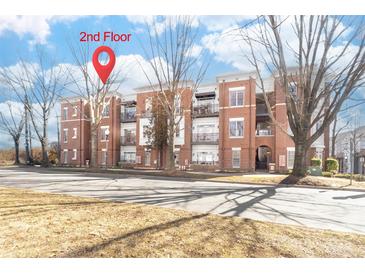 Two story brick condo building featuring balconies and manicured landscaping at 780 N Davidson St, Charlotte, NC 28202