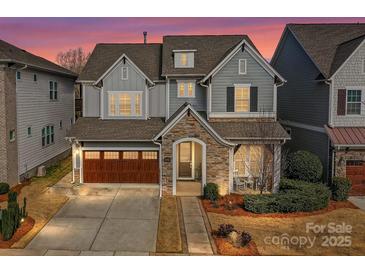 Charming two-story home with stone accents, a two-car garage, and a well-manicured front yard at 9730 Briarwick Ln, Charlotte, NC 28277