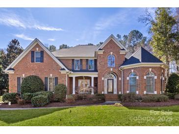 Stately brick home featuring a manicured lawn and a classic arched entryway at 1016 Antioch Woods Ln # 36, Weddington, NC 28104