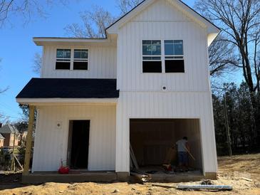 New two-story home featuring bright white siding, a black roof, and an attached garage under construction at 103 Irwin St, Cherryville, NC 28021