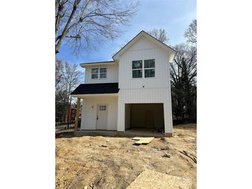 New construction featuring white vertical siding, black roof, and a convenient drive-under garage at 103 Irwin St, Cherryville, NC 28021