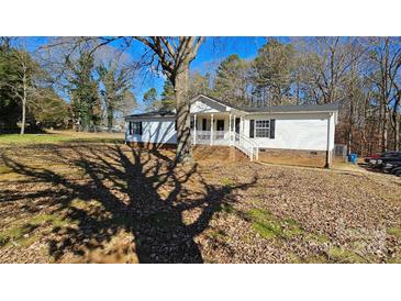 White single story home with covered porch and brick foundation at 10386 Turnplow Dr, Davidson, NC 28036