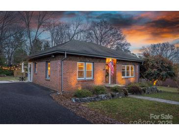 Brick ranch home with landscaped yard, illuminated at dusk at 1334 7Th Nw St, Hickory, NC 28601