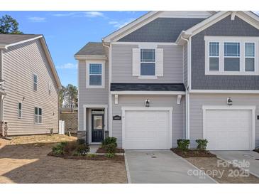 Charming gray townhome with a one-car garage, dark trim and complementary landscaping at 16022 Red Buckeye Ln, Huntersville, NC 28078