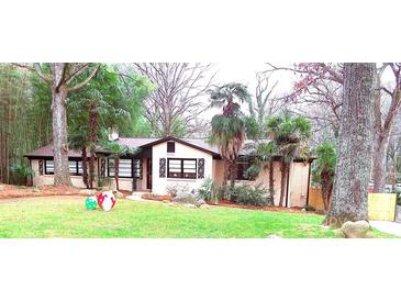 Brick ranch home with palm trees and landscaped yard at 1723 Oak St, Charlotte, NC 28269