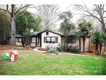 Charming brick home with mature landscaping, a cozy front yard, and unique seasonal decorations at 1723 Oak St, Charlotte, NC 28269