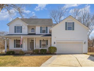 Charming two-story home featuring a welcoming front porch, attached garage, and manicured landscaping at 4763 Brockton Nw Ct, Concord, NC 28027