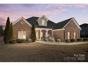 Brick home with landscaped yard, large windows and a welcoming porch at 573 Church St, Locust, NC 28097