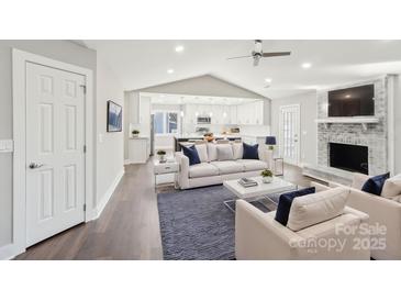 Open living room featuring a fireplace and kitchen views at 603 Canadice Rd, Huntersville, NC 28078