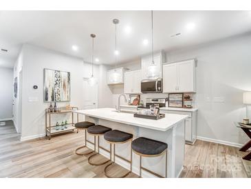 Bright kitchen features an island with seating, quartz countertops and stainless steel appliances at 608 Cassidy Ct, Clover, SC 29710