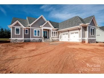 A beautiful home with gray siding, stone accents, and a two-car garage at 6098 Ballard Rd, Denver, NC 28037