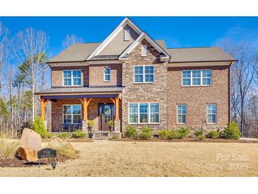 Beautiful two-story brick home with stone accents, a covered front porch, and well-manicured lawn at 7191 Three Kings Rd, Fort Mill, SC 29715