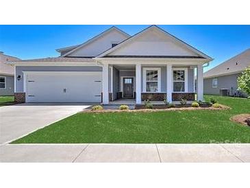 New construction home with gray siding, white trim, and a landscaped lawn at 110 Sari St, Troutman, NC 28166