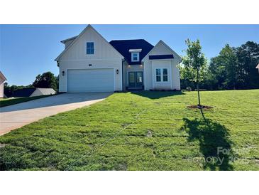 Charming cream-colored, two-story home with a well-manicured lawn and attached two-car garage at 136 Autumn Blaze Rd, China Grove, NC 28023