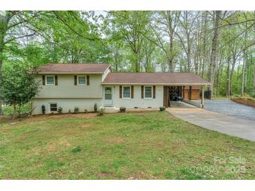 Charming split-level home featuring a well-manicured lawn, painted brick, and an attached carport at 170 Woodcrest Rd, Mooresville, NC 28115