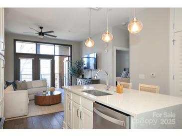 Open concept kitchen with island seating overlooking the living room at 2401 Euclid Ave # 110, Charlotte, NC 28203