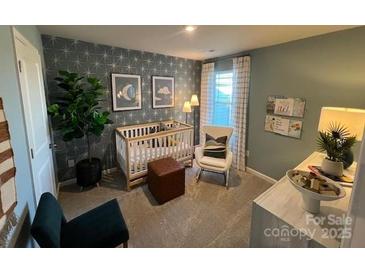 This delightful bedroom features a crib, chair, and decorative wall art at 264 Laura Elizabeth Ln, Clover, SC 29710