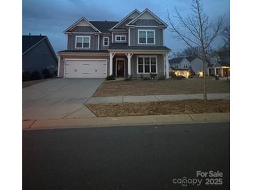 Two-story house with gray siding, white trim, and a three-car garage at 3041 Winged Teal Ct # 57, Belmont, NC 28012