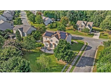 Stunning aerial view of a house with solar panels, a patio, and lush landscaping at 712 Springwood Dr, Waxhaw, NC 28173