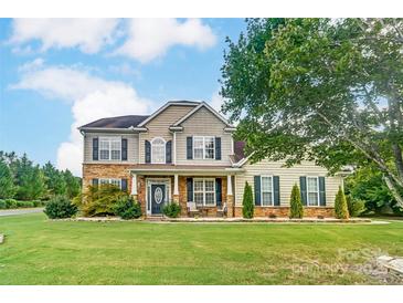 Charming two-story home featuring stone accents, a manicured lawn, and inviting front porch at 712 Springwood Dr, Waxhaw, NC 28173