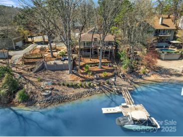 Charming waterfront home with a private dock, expansive deck, and lush landscaping at 1077 Gauguin Ln, Tega Cay, SC 29708