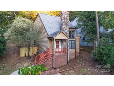 A charming two-story home with a stone fireplace and red stairs at 27097 Cove Ln, Tega Cay, SC 29708